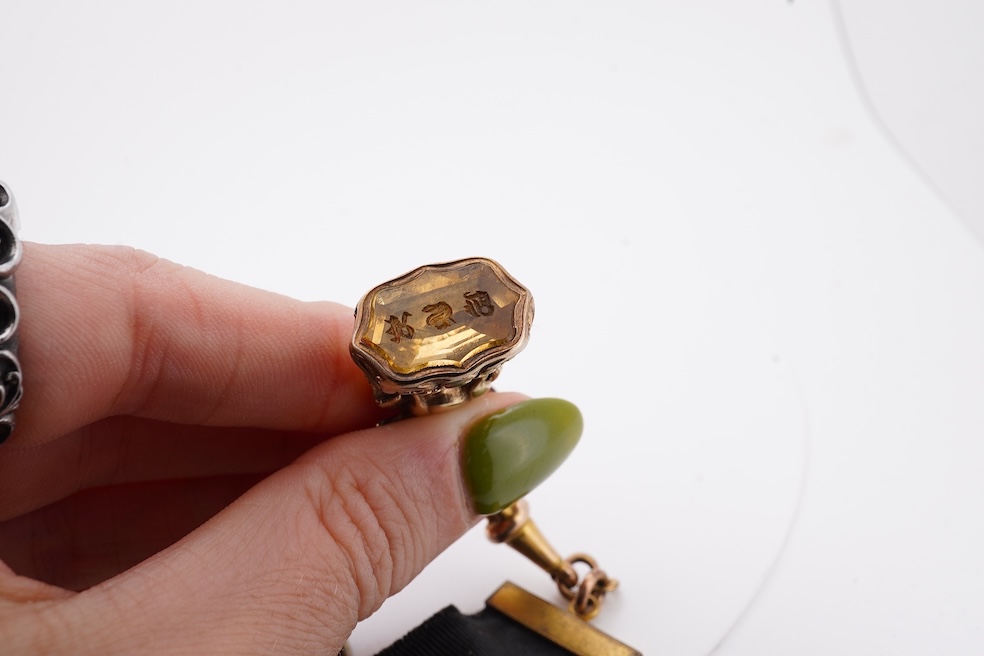 A late Victorian yellow metal overlaid and citrine set watch key fob, depicting two horses and two rams?, 30mm on a black sash suspension, together with a modern pair of 9ct gold and cultured pearl set leaf ear studs. Co